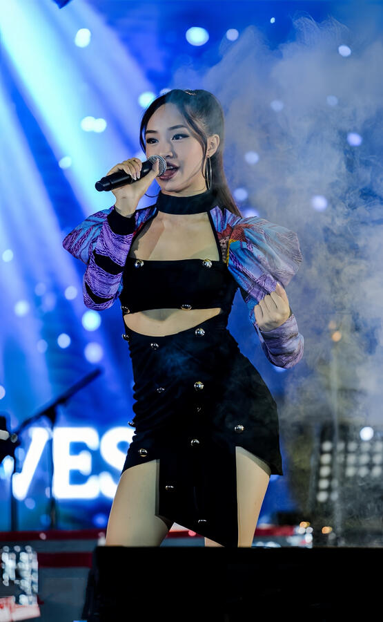 Angeli Chaves singing in cropped black outfit and purple jacket during Sofronio Vasquez Tour Winnipeg show